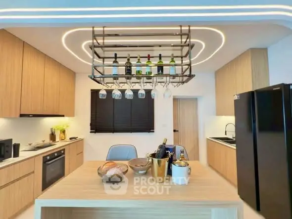 Modern kitchen with sleek wooden cabinetry and stylish lighting, featuring a wine rack and contemporary appliances.