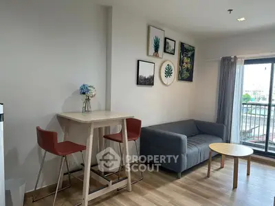Modern living room with stylish decor and balcony view, featuring a cozy sofa and chic dining area.