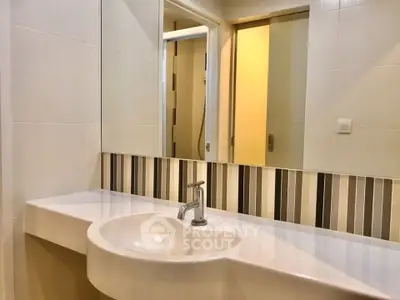 Modern bathroom with sleek sink and stylish striped backsplash