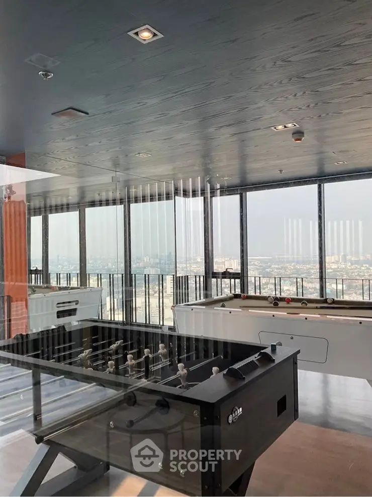 Stunning high-rise building with game room featuring foosball and pool tables, offering panoramic city views.