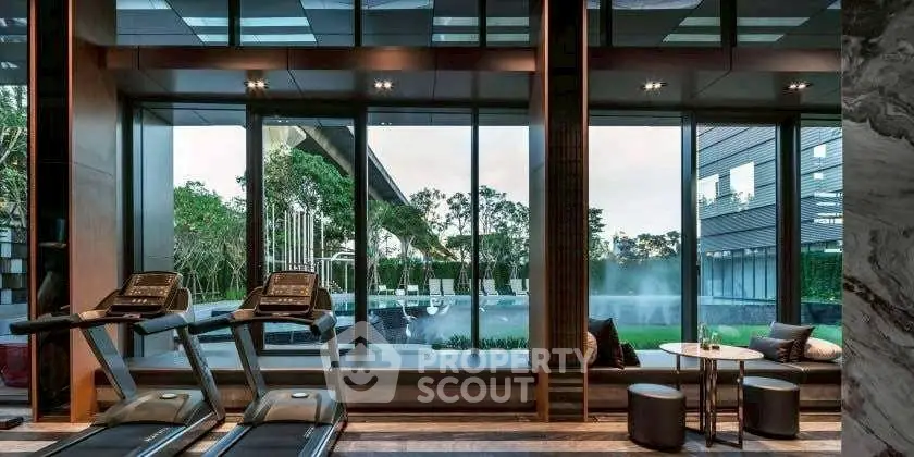 Luxurious gym with modern equipment and stunning garden view through large windows.