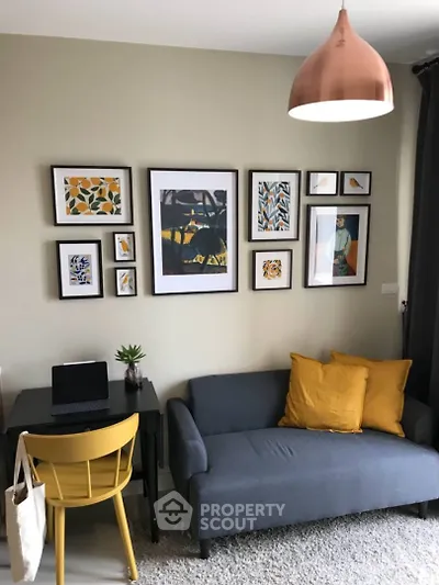 Stylish living room with modern decor, featuring a cozy sofa, vibrant artwork, and a chic pendant light.