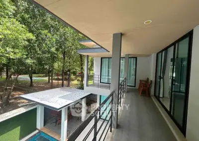 Modern balcony with pool view in a serene forest setting