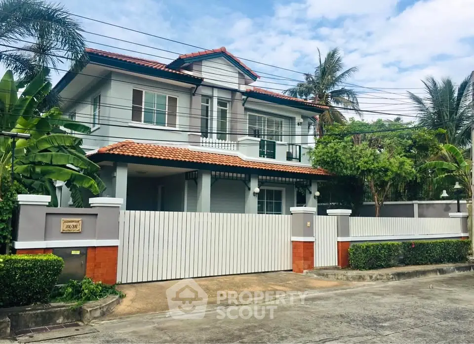Charming two-story house with lush greenery and modern design in a serene neighborhood.