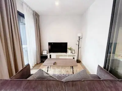 Modern living room with sleek furniture and large TV, perfect for relaxation and entertainment.