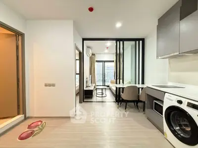 Modern apartment interior with open kitchen and washing machine, bright and spacious layout.