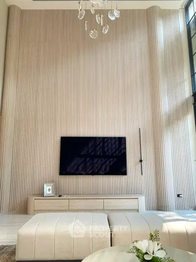 Luxurious modern living room with high ceilings and elegant wall paneling