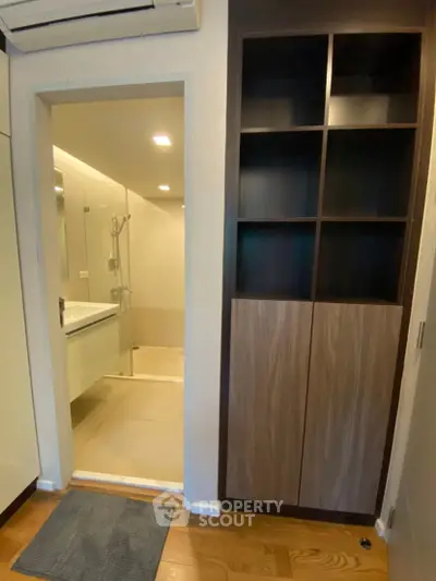 Modern bathroom entrance with sleek shelving and wooden flooring
