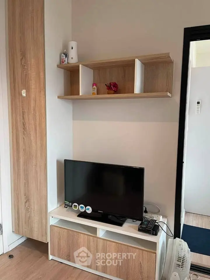 Modern living room with sleek TV stand and wooden shelving, perfect for cozy entertainment.