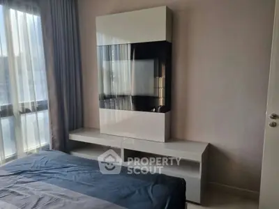 Modern bedroom with sleek furniture and large window for natural light