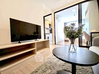 Modern living room with sleek TV setup and cozy decor in a stylish apartment.