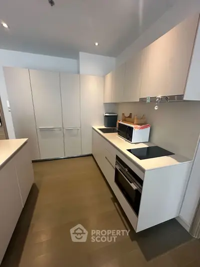 Modern kitchen with sleek cabinetry and built-in appliances in a contemporary apartment.