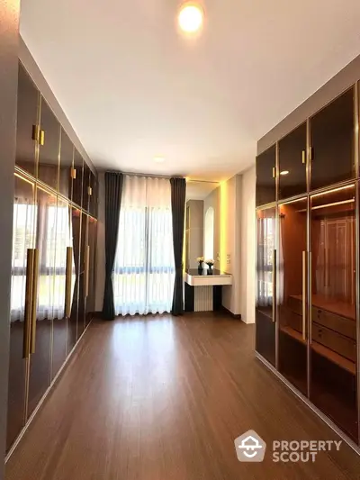 Luxurious walk-in closet with elegant wooden flooring and ample storage space