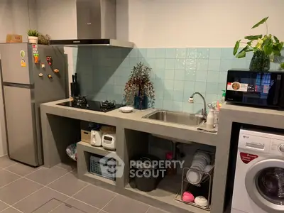 Modern kitchen with concrete countertops, gas stove, and washing machine