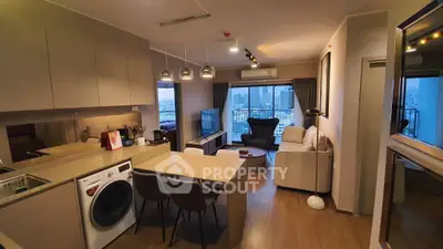 Modern open-layout living room with kitchen, featuring city view and stylish furnishings.