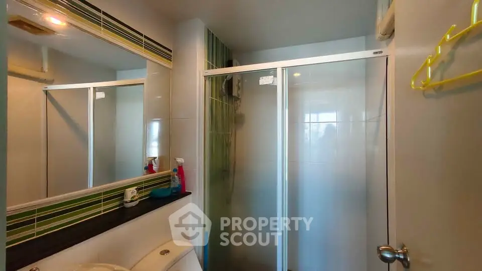 Modern bathroom with glass shower enclosure and stylish tile accents.
