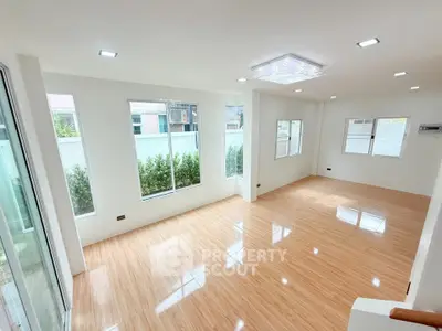 Spacious and bright living room with wooden flooring and large windows