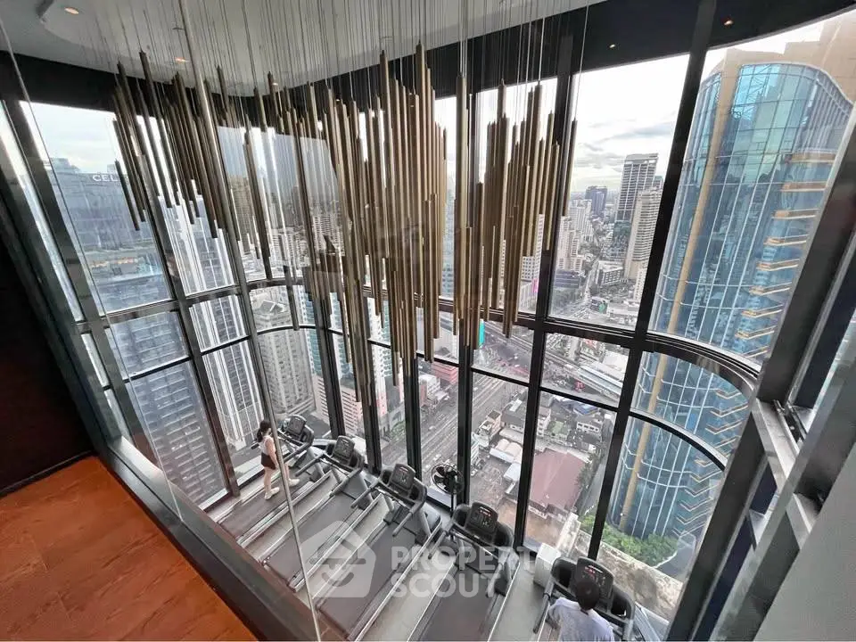 Luxurious gym with panoramic city view and modern equipment in high-rise building.