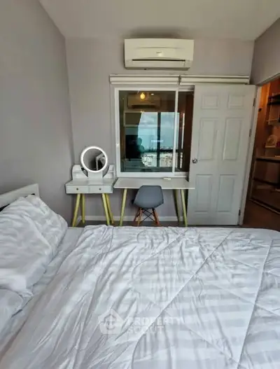 Cozy bedroom with modern decor and city view, featuring a stylish desk and comfortable bed.