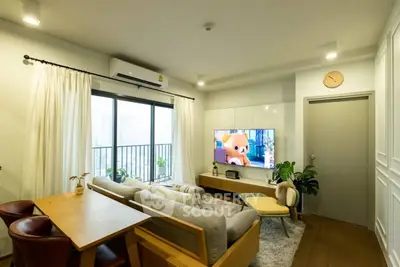 Modern living room with cozy furniture and balcony view, perfect for relaxation and entertainment.