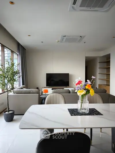 Modern living room with elegant decor and large windows offering natural light
