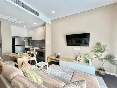 Modern living room with open kitchen, stylish decor, and cozy seating area in a contemporary apartment.