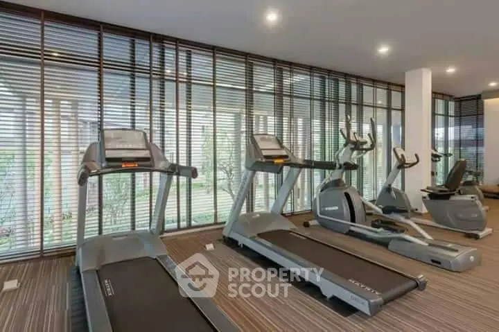Modern gym with treadmills and exercise bikes in a well-lit fitness center.