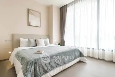 Spacious and bright bedroom with large windows and modern decor