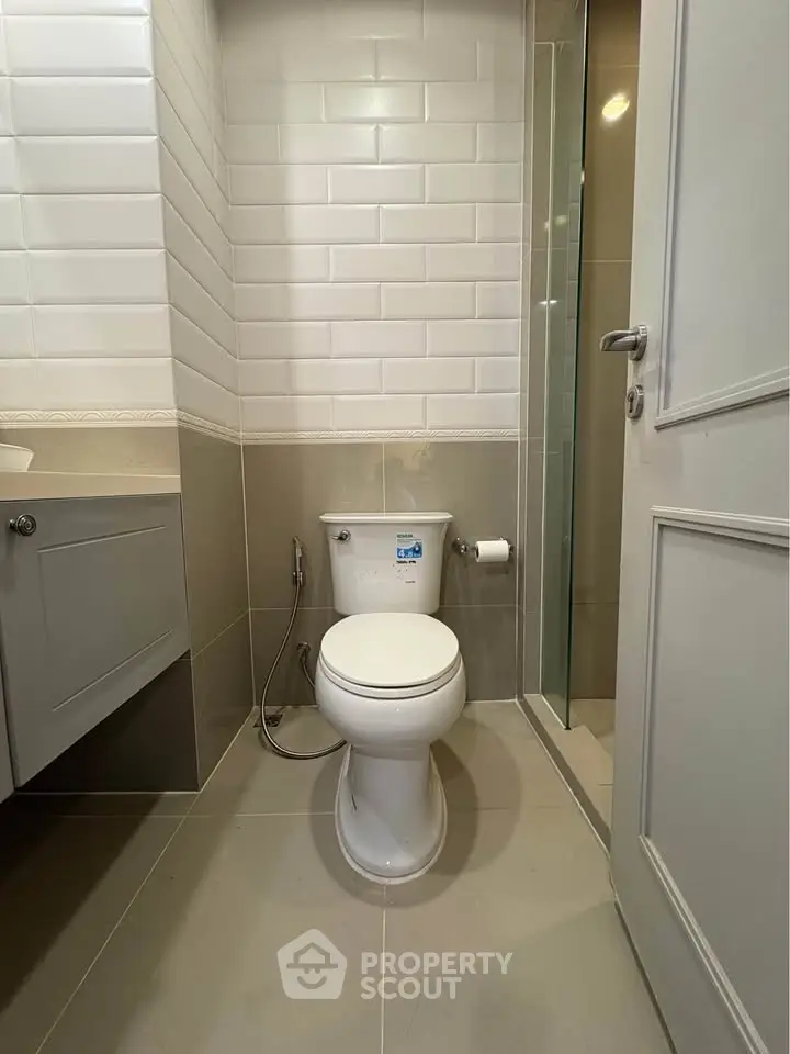 Modern bathroom with sleek white tiles and contemporary fixtures.