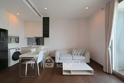 Modern living room with sleek kitchen and cozy sofa in open layout apartment.