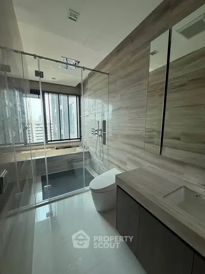 Luxurious modern bathroom with glass shower and city view, featuring sleek fixtures and elegant design.