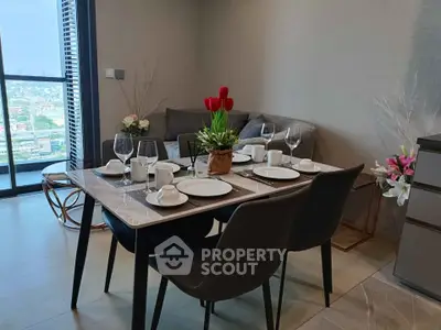 Modern dining area with elegant table setting and city view from balcony.