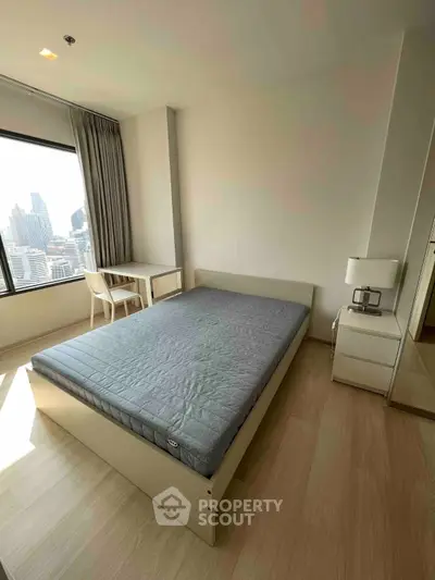 Modern bedroom with city view, featuring a minimalist design and ample natural light.
