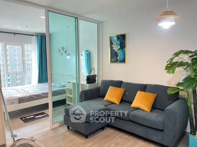 Modern living room with cozy sofa and view into stylish bedroom