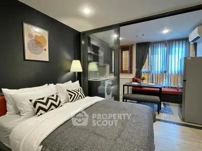Modern studio apartment with stylish decor and open layout, featuring a cozy bed and compact living area.