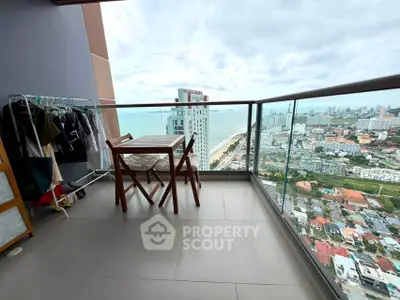 Stunning high-rise balcony with ocean and city views, featuring cozy seating and ample space for relaxation.