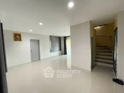 Spacious modern living room with sleek staircase and natural light