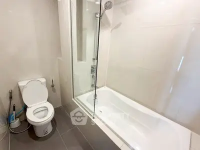 Modern bathroom with sleek bathtub and shower combination, featuring minimalist design and neutral tones.