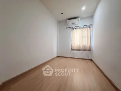 Spacious empty room with wooden flooring and air conditioning, perfect for customization.