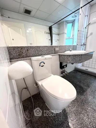 Modern bathroom with sleek fixtures and granite countertops in a contemporary apartment.