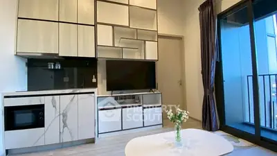 Modern living room with sleek cabinetry and balcony view