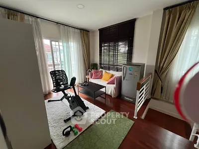 Charming living room with exercise bike and cozy seating area, perfect for relaxation and fitness.
