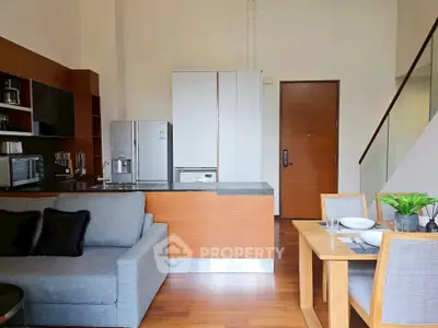 Modern open-plan kitchen and living area with sleek design and wooden accents.