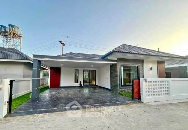 Modern single-story house with spacious driveway and contemporary design.