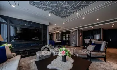 Luxurious living room with elegant decor and modern furnishings, featuring a large TV and stylish ceiling design.
