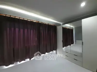 Sleek modern bedroom with ambient lighting, plush curtains, and built-in glossy wardrobes reflecting a minimalist design ethos.