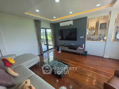 Spacious living room with modern decor and large glass doors leading to a balcony.