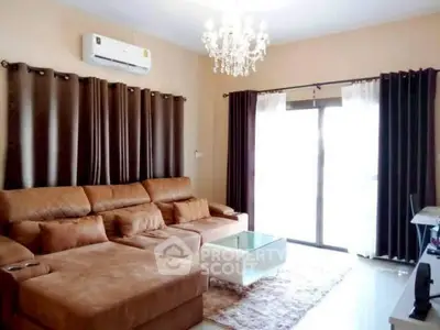 Luxurious living room with elegant chandelier and plush brown sofa