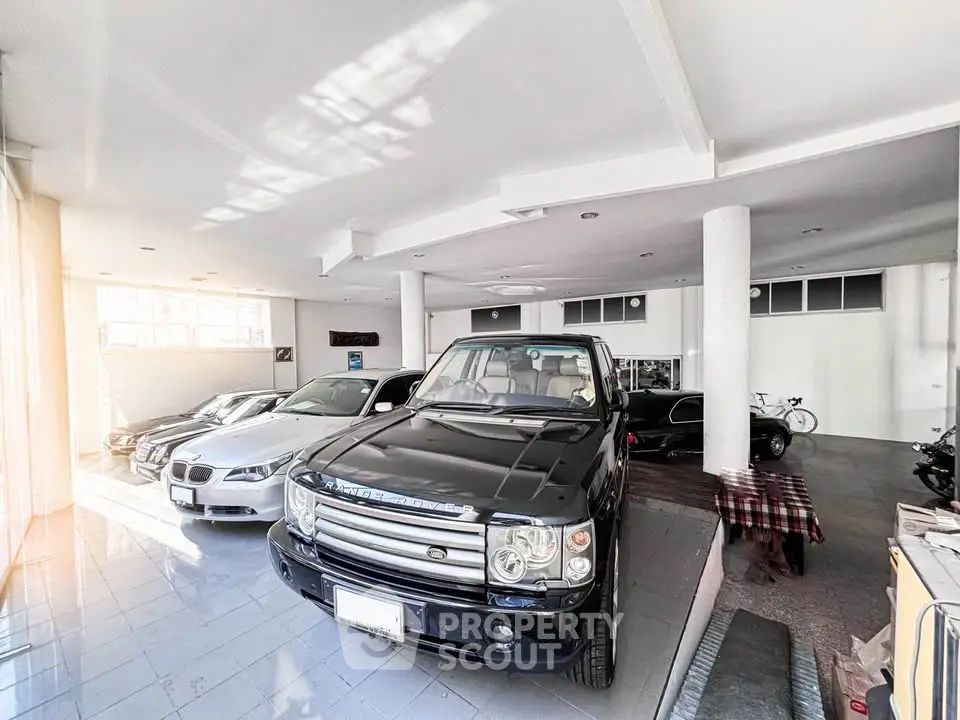 Spacious indoor parking with luxury cars in a modern garage setting.