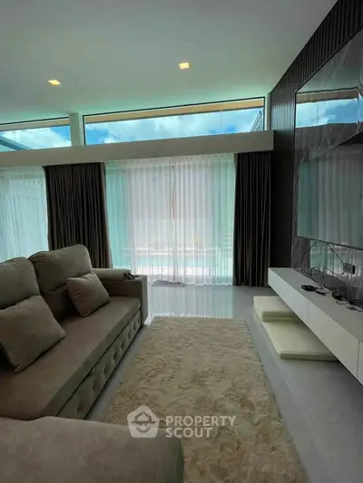 Luxurious living room with modern decor and large windows offering natural light.